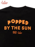 Black t-shirt with orange text 'Popped by the Sun' and brand logo on a white background