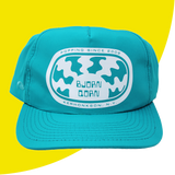 Teal cap with white logo and text on a yellow background