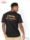 Person wearing a black t-shirt with 'Popped by the Sun' text on the back, standing against a white background.